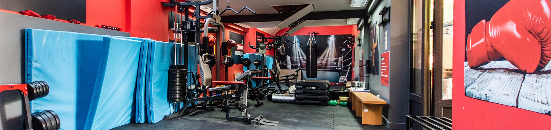 Wnętrze siłowni. Na czerwonej ścianie napis: \\\\"Nigdy się nie poddawaj. Na wielkie rzeczy potrzeba czasu.\\\\"